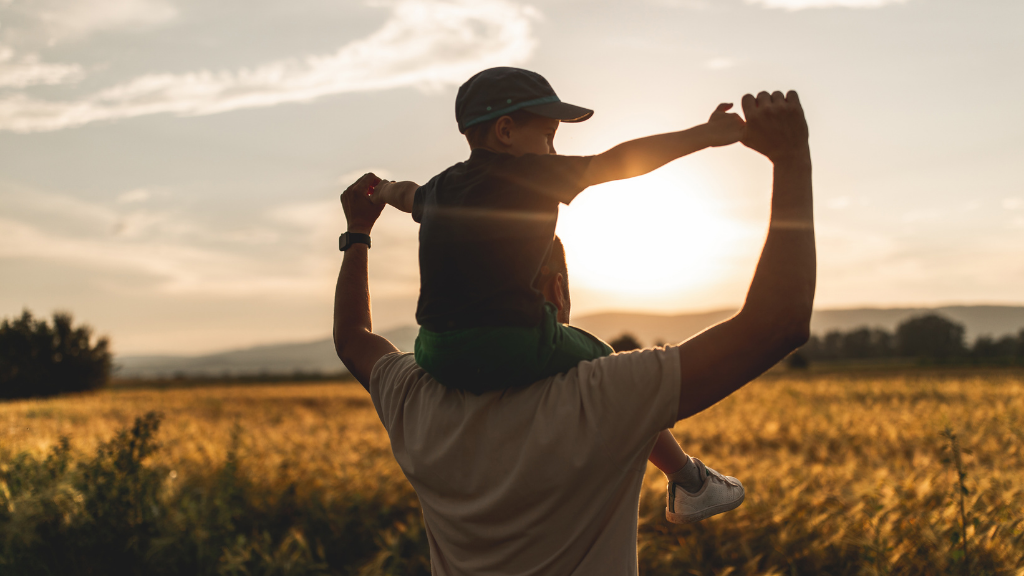 father and son looking at sunset together