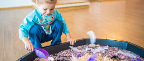child playing with sensory tray
