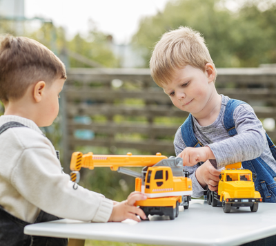boys playing with construction truck toys