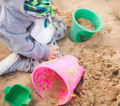 toddler playing in sandpit