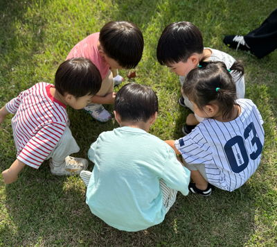 children grouped in circle on grass