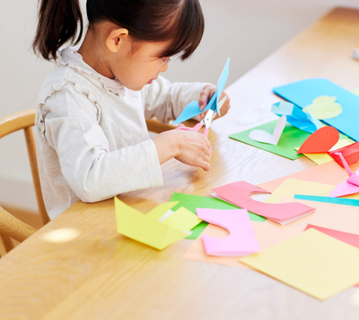 child cutting paper with scissors
