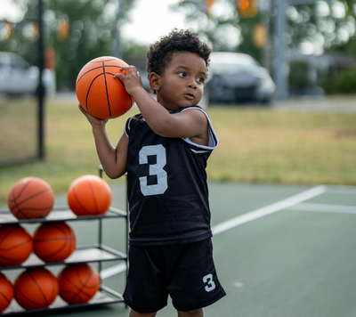 Basketball child holding basketball on court