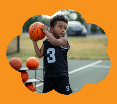 child holding basketball on court