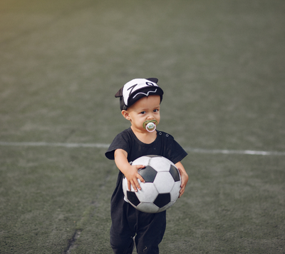 Soccer child holding soccer ball to play