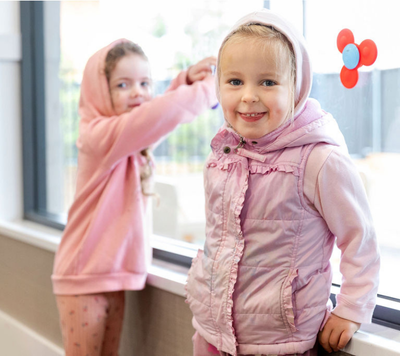two girls smiling and wearing pink