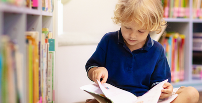 boy reading book on floor