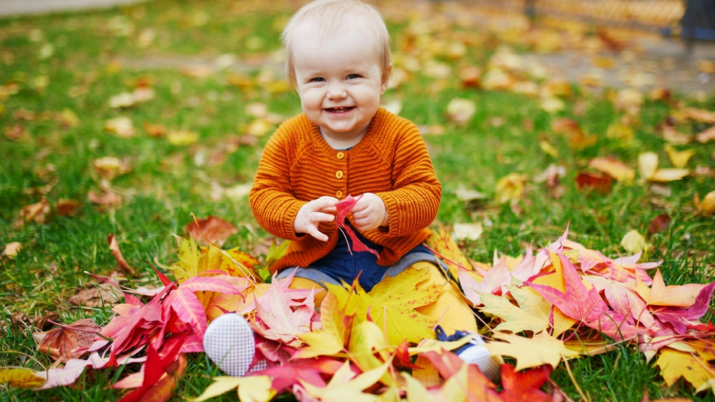 child playing in leaves